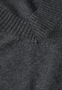 Dunkelgrauer Pullover mit V-Ausschnitt und geripptem Textur am Kragen und Saum. Der Stoff wirkt weich und leicht flauschig.