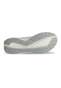 Baskets blanches avec une semelle extérieure en caoutchouc gris texturé, présentant un motif de bande de roulement distinctif et un logo en relief sur le côté.