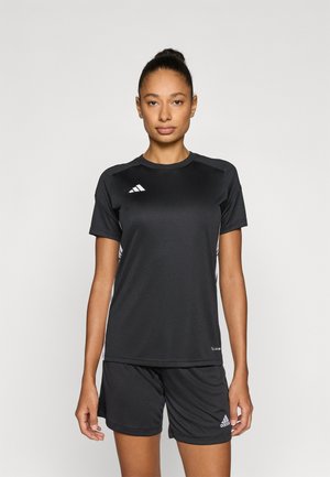 Czarny sportowy strój z koszulką i spodenek wykonany z gładkiego materiału. Z białymi akcentami logo i wzorami po bokach. Krótkie rękawy i okrągły dekolt.