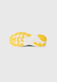 Semelle de chaussure avec une base blanche, des motifs de traction en caoutchouc jaune, une surface texturée et une forme large et stable conçue pour l'adhérence.