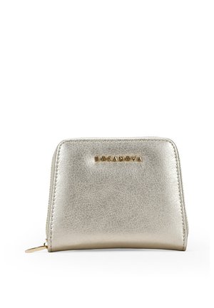 Bolsa de cuero sintético plateado metálico con una superficie texturizada, que presenta un logo dorado en relieve y un cierre de cremallera. Diseño compacto y rectangular.