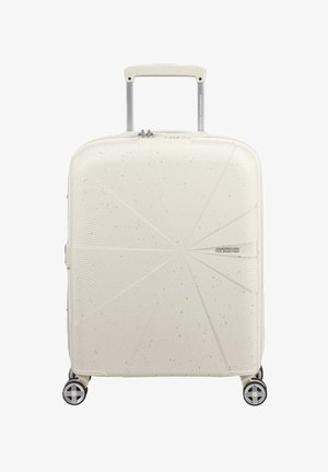 Maleta rígida en color blanco roto, con un diseño texturizado y patrones de explosión de estrellas, un mango retráctil y cuatro ruedas giratorias.