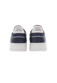 Marinblå sneakers med vita accenter, en texturerad läderöverdel och gummisula. Har "SINCE 1890" tryckt på baksidan. Minimalistisk design.