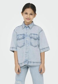 Ljusblå denimskjorta med korta ärmar, två framfickor och krage. Har detaljerad sömnad och en avslappnad passform.