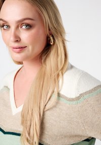 Pull à col en V avec des rayures horizontales beige, vert menthe et vert foncé ; texture douce avec une coupe décontractée et un col côtelé.