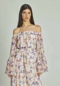 Blumenkleid mit schulterfreiem Schnitt aus leichtem Stoff; verfügt über geraffte Ärmel, eine taillierte Taille mit einem Blumenbandeau und sanften lila und rosa Mustern.