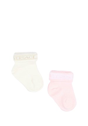 Due piccoli calzini per neonati, uno crema e uno rosa, ciascuno con un polsino piegato e un motivo di testo sottile sul polsino.