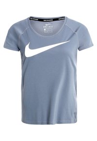 Camiseta deportiva de manga corta en azul claro con el logo de Nike en forma de swoosh blanco. Fabricada con material Dri-FIT, presenta un cuello redondo y un diseño sin costuras.