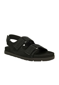 Sandali neri in suede con due cinturini regolabili in Velcro e suola in gomma. Design piatto con punta aperta e supporto per il tallone posteriore per una facile calzata.