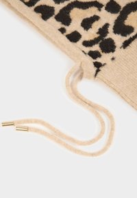 Sciarpa in maglia beige con motivo a stampa leopardata nera. Include cordini con estremità in metallo dorato. Texture morbida e forma strutturata.