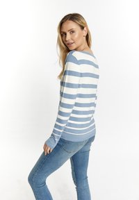 Šviesiai mėlynas ir baltas raižytas megztinis su ilgomis rankovėmis ir plačiu iškirpimu. Turi prigludusį dizainą ir gumines rankoves. Dėvimas su mėlynomis džinsomis.