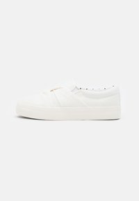 Weiße Slipper-Sneaker mit einem geknoteten Stoffdesign oben, flacher Gummisohle und gepolstertem Kragen mit schwarzem Pünktchen-Futter.