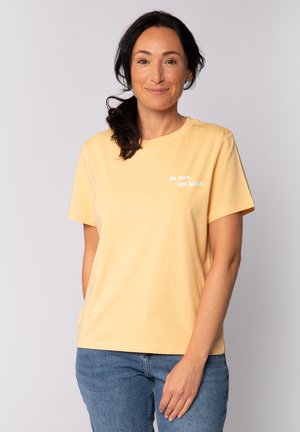 T-shirt en coton jaune à manches courtes et col rond. Présente un texte blanc dans une police décontractée sur la zone gauche de la poitrine. Coupe décontractée.