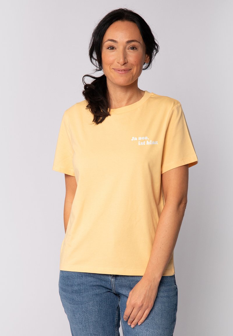 Geel katoenen t-shirt met korte mouwen en een ronde halslijn. Bevat witte tekst in een casual lettertype op de linkerkant van de borst. Casual pasvorm.