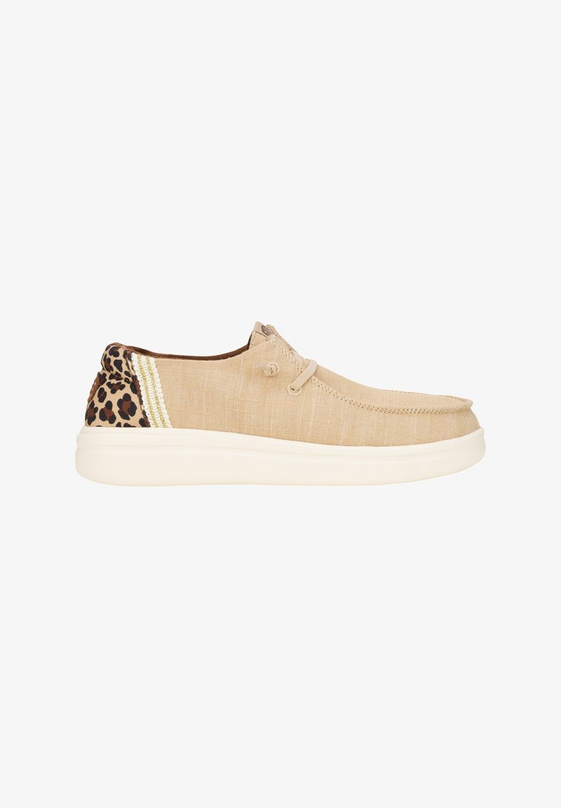 Chaussure en tissu beige avec une finition texturée, présentant des accents de léopard et des rayures sur le talon, ainsi qu'une semelle en caoutchouc blanche.