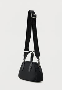 Μαύρη τσάντα χειρός με στρογγυλό σχήμα, κατασκευασμένη από λείο υλικό. Διαθέτει διπλές λαβές, αποσπώμενο λουράκι με λογότυπο και ασημί μεταλλικά στοιχεία.