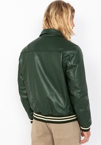 Groene leren bomberjack met een geribbelde kraag en manchetten, gladde textuur en contrasterende gestreepte tailleband. Beschikt over een klassiek ontwerp.
