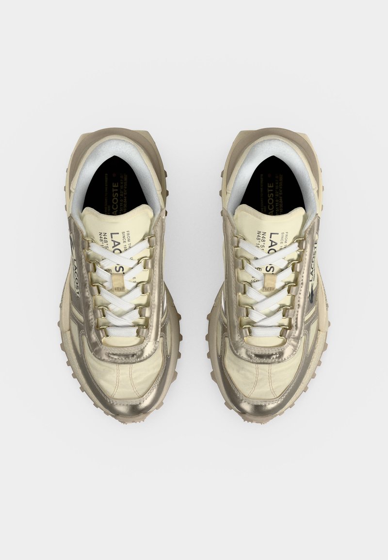 Paar cremefarbene und beige Lacoste-Sneaker mit weißen Schnürsenkeln, von oben auf hellem Hintergrund gesehen.