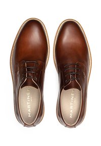 Chaussures en cuir marron à lacets avec une finition lisse, bout rond et coutures contrastées le long de la semelle. Logo doré sur la semelle intérieure.