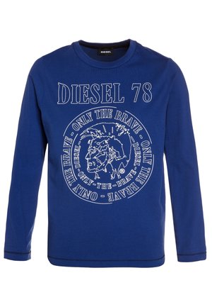 Niebieska koszula z długim rękawem z napisem "DIESEL 78" oraz okrągłym logo przedstawiającym stylizowaną męską twarz i powtarzającym się napisem "ONLY THE BRAVE".