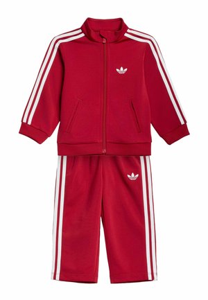 Rød toddler-tracksuit med hvide striber på ærmer og bukser, lynlåsjakke og Adidas trefoil-logoer på bryst og bukser.
