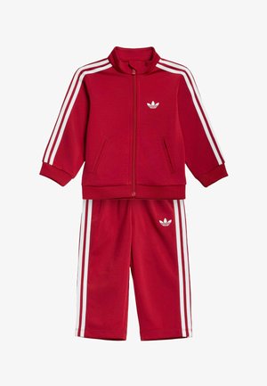 Roter Kleinkinder-Trainingsanzug mit weißen Streifen an Ärmeln und Hosen, Reißverschlussjacke und Adidas-Trefoil-Logos auf Brust und Hose.