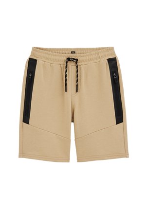 Pantalones cortos casuales beige con cintura elástica, cordón negro y bolsillos laterales con cremallera negra, diseñados para comodidad y funcionalidad.