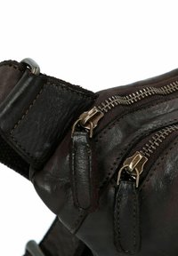 Borsa in pelle marrone con varie tasche con zip, superficie texturizzata e cuciture a contrasto. Include accessori in metallo funzionali.