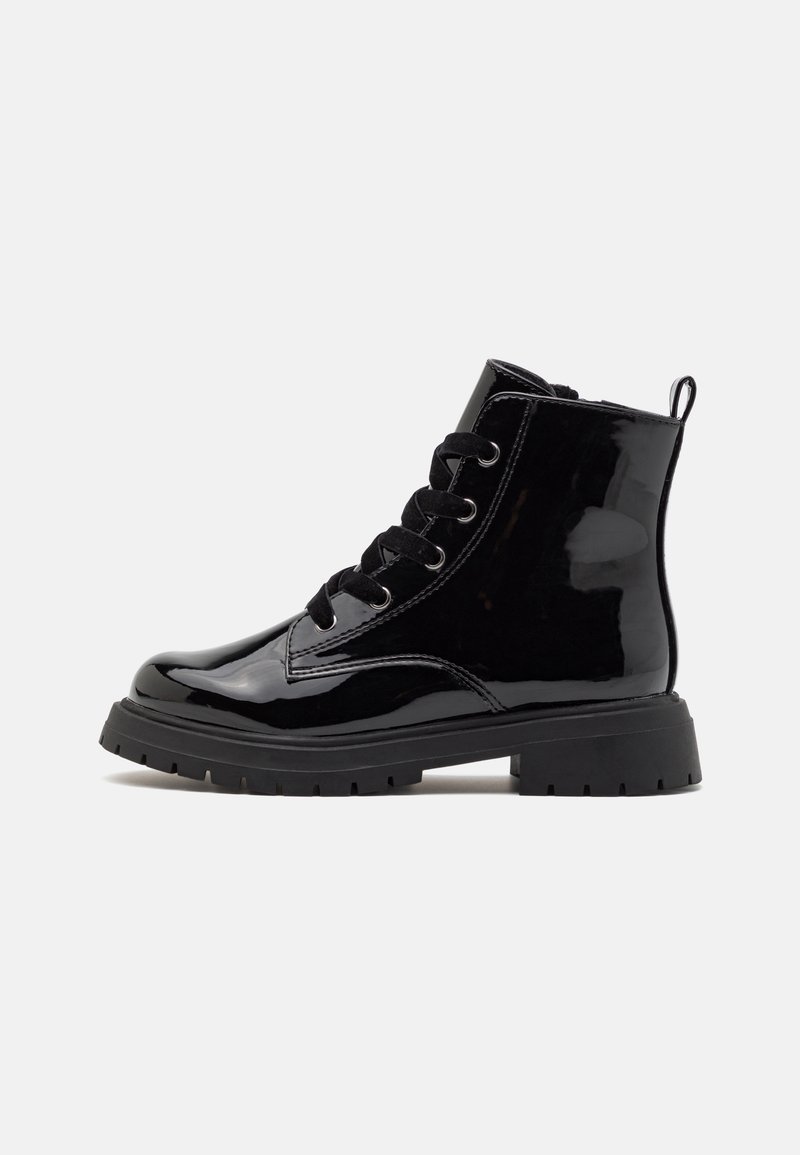 Bottine en cuir verni noir avec lacets à l'avant, semelle épaisse à crampons et languette à l'arrière, sur un fond gris clair.