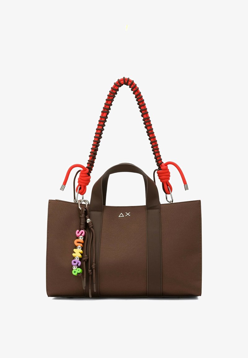 Borsa rettangolare marrone con manici larghi, tracolla intrecciata rossa e nera, e charm colorati a forma di lettere e numeri appesi sul lato.