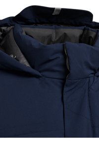 Niebieska granatowa kurtka wewnątrz z wysokim kołnierzem, gładkiego syntetycznego materiału, z minimalistycznymi detalami wzdłuż szwów.