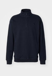 Sudadera pullover de color azul marino con cuello alto, cremallera en el cuello y un diseño de puños ajustados. Presenta un logotipo sutil en el pecho.
