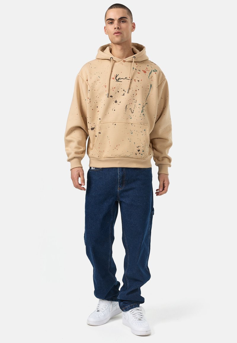 Karl Kani - SMALL SIGNATURE PAINTSPLATTER HOODIE - Džemperis su gobtuvu - sand, Padidinti