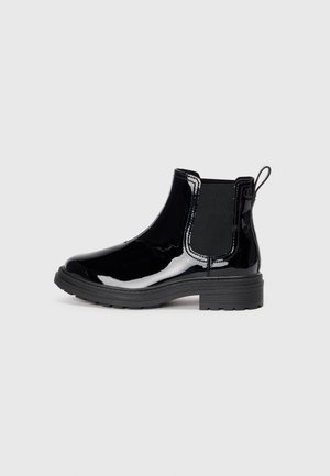 Bottes chelsea noires en cuir verni avec un bout rond, des panneaux élastiques sur les côtés, une languette de tirage et une semelle en caoutchouc texturée. Design à talon bas.