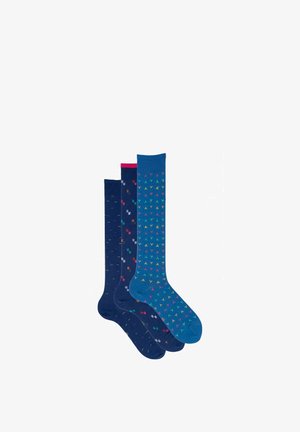 Drei Paar blaue knielange Socken mit bunten kleinen geometrischen Mustern, jedes Paar leicht unterschiedlich im Farbton und Design.