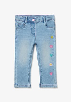 Jeans azzurri chiaro per bambini piccoli con cuciture rosa e toppe colorate a forma di cuore e fiore su una gamba.