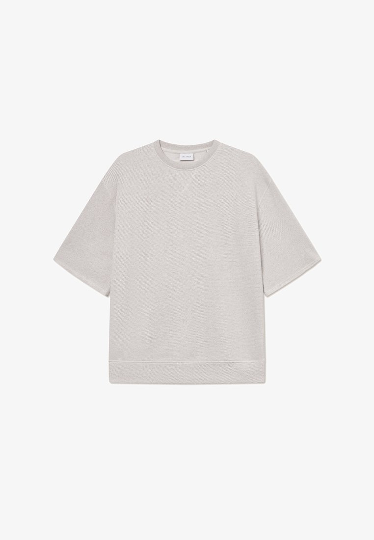 Světlé šedé oversized tričko vyrobené z texturované látky, s krátkými rukávy a kulatým výstřihem s žebrovaným lemem.