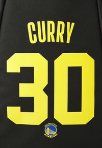 Black Golden State Warriors jersey with yellow text showing "CURRY" and number "30" in large font.