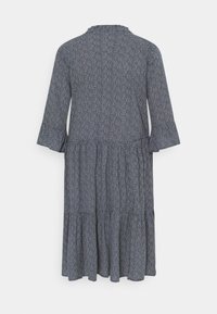 Marinblå klänning med vit mönstring, utsvängda trekvartsärmar, lager på lager-skirt och ett mjukt texturerat tyg, med en rund halsringning.