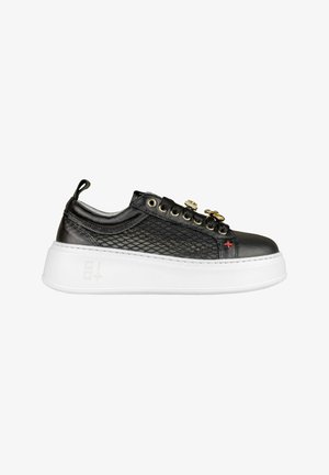 Sneaker nera con una tomaia in mesh testurizzato, lacci piatti, occhielli dorati, hardware decorativo e una spessa suola piatta bianca.