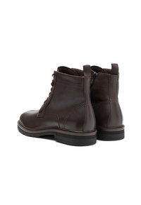 Botine din piele maro, cu o textură netedă, cu șireturi în față și fermoar lateral. Au un vârf rotund și o talpă din cauciuc.