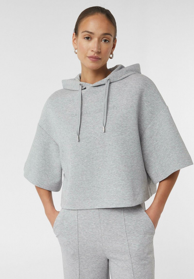 Hellgraue, gekürzte Kapuzenpullover mit Zugkordel, kurzen Ärmeln und dezentem Logodetail. Hergestellt aus weichem, strukturiertem Stoff für zusätzlichen Komfort.