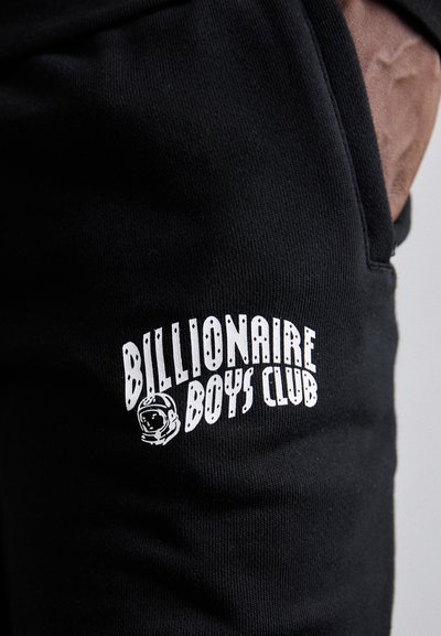 Jogger din bumbac negru cu un imprimeu alb reprezentând "Billionaire Boys Club" și un emblema cu astronaut pe coapsa stângă.