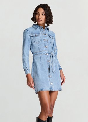 Robe-chemise en denim bleu clair, dotée de manches longues, poches poitrine, taille ceinturée et fermeture à boutons. Texture lisse avec légère usure.