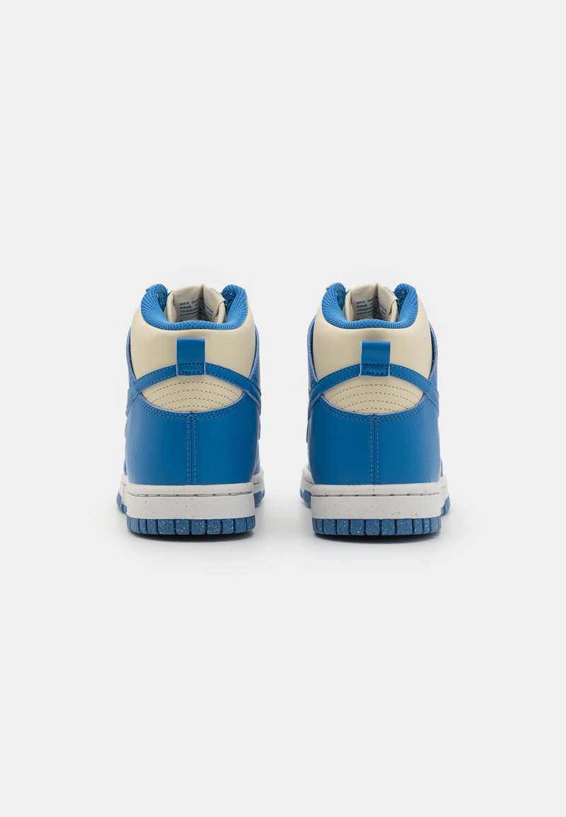 Niebieskie skórzane sneakersy za kostkę z białymi akcentami, teksturowanymi panelami, wyściełanym kołnierzem i gumową podeszwą z niebieskim wzorem bieżnika.
