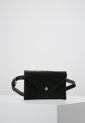 Sac banane noir à texture imitation crocodile avec rabat en forme d'enveloppe et bouton-pression argenté, sangle réglable présentée sur une surface blanche.