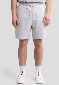 Graue Baumwoll-Sweatshorts mit elastischem Bund, verstellbarem Kordelzug und seitlichen Taschen. Bemerkenswerte Merkmale sind die geraden Beine und die weiche Textur.