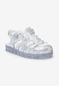 Klare Jelly-Sandale mit silbernem Glitzer, Riemendetails, offenem Zehenbereich und strukturierter Sohle. Leichtes und flexibles Design.