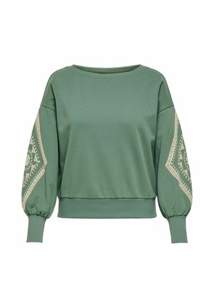 Zelena majica z mehurčastimi rokavi, z bež vezenjem vzdolž rokavov. Iz mehkega blaga, z ohlapnim krojem in okroglim izrezom na vratu.