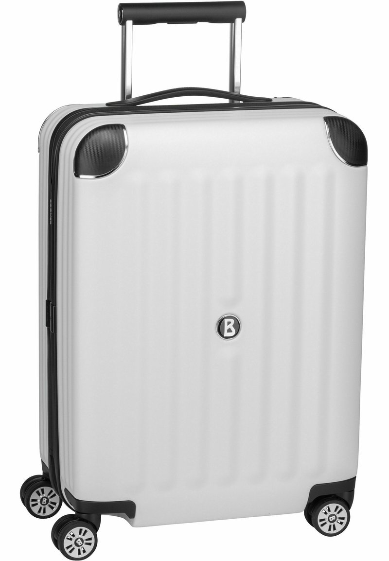 Biała twarda walizka z pionowymi żłobieniami, czarnymi detalami, metalowym uchwytem i czterema obrotowymi kółkami. Na przodzie znajduje się logo.